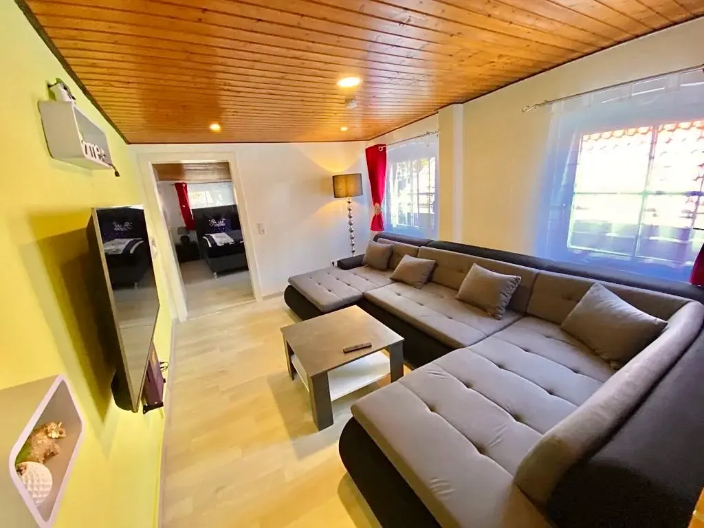 Wohnzimmer mit Sofa und Flachbild-TV